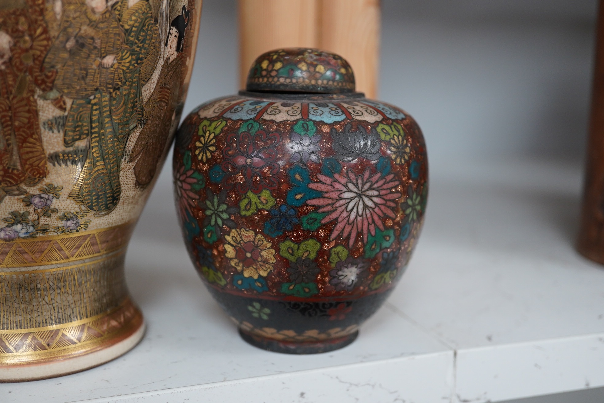 A pair of Japanese cloisonné enamel jars and covers, a Japanese bronze and gold overlaid small vase and a Satsuma pottery vase, tallest 22cm high (4). Condition - finial loose and one missing on cloisonné jars and covers